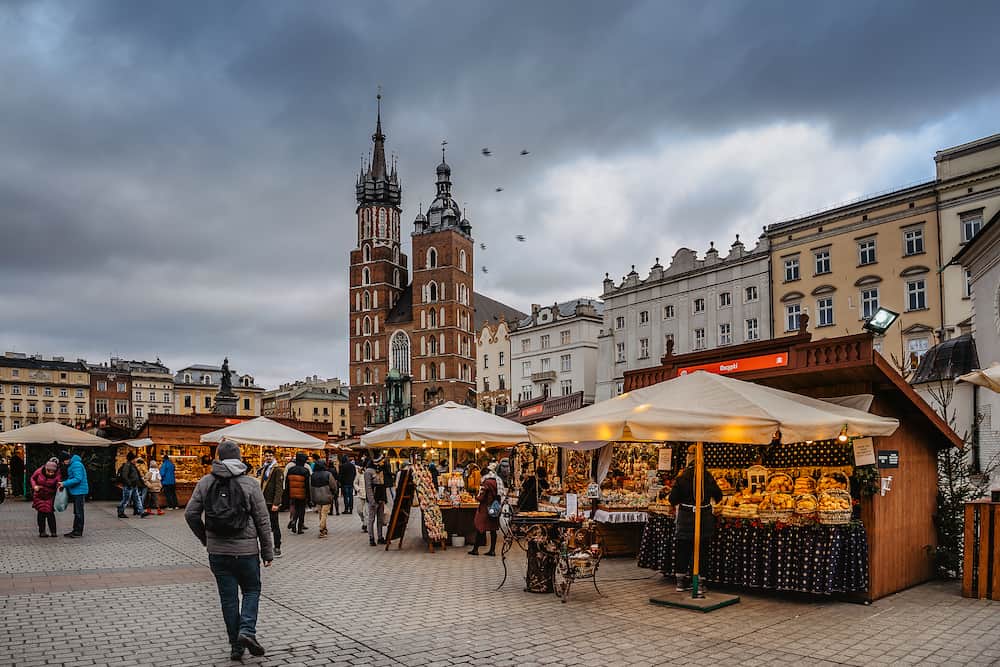 Krakow,Poland- Famous Christmas market on main square,Rynek Glowny,decorated timber huts with smoked cheese,hot wine and other Polish specialties.People enjoying festive atmosphere.