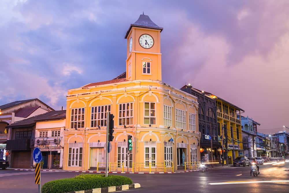 Phuket Thailand , Landmark chino-portuguese clock tower in phuket old town, Thailand, with light trails on road in twilight time.