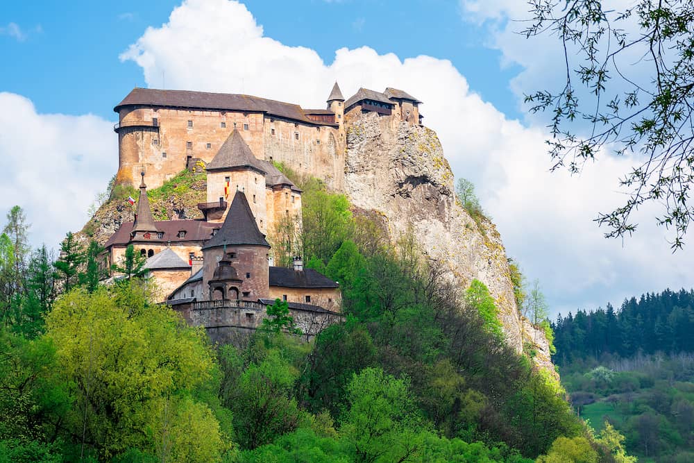 medieval orava castle on the hill. beautiful springtime scenery in dappled light above the river. popular travel destination of slovakia