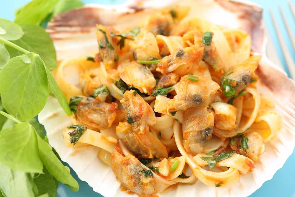 dish of portuguese clams "conquilhas" with pasta and tomato sauce