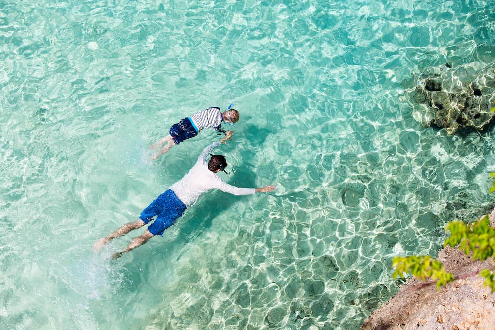 above view at family of two snorkeling at anguilla enjoying caribbean sea active lifestyle concept