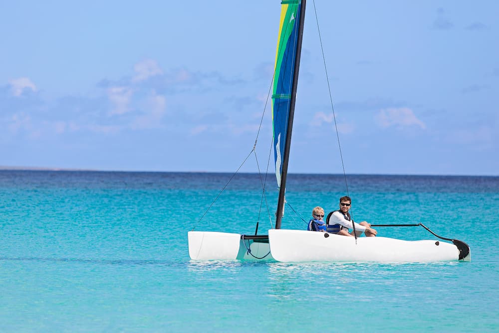 family of two father and son enjoying sailing together at hobie cat catamaran active healthy lifestyle