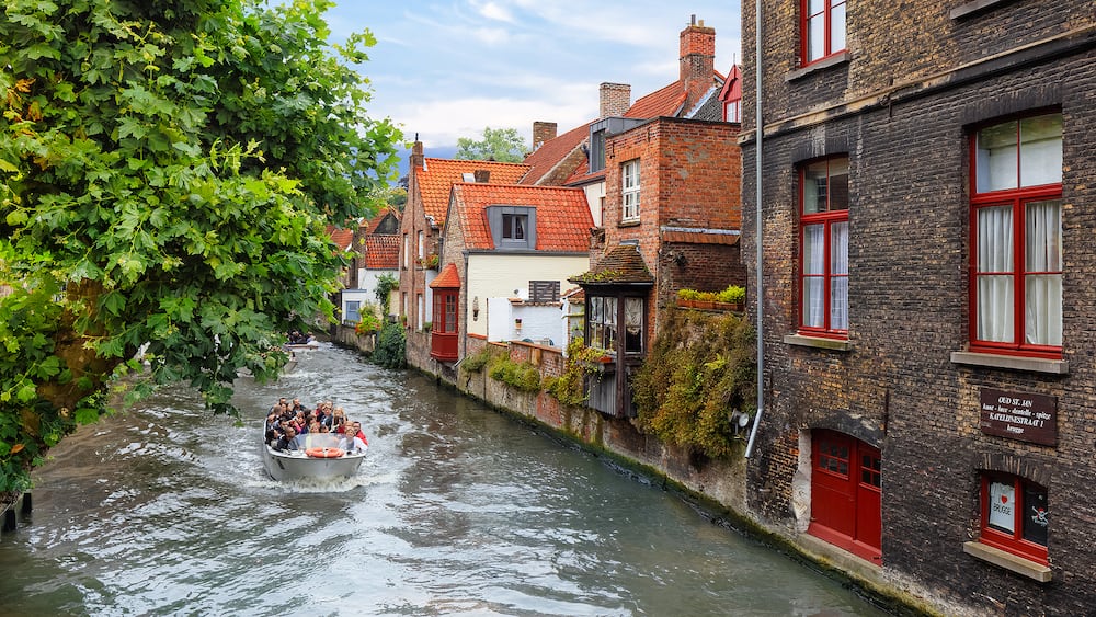 Bruges, Belgium - Tourists taking boat tour around medieval canals