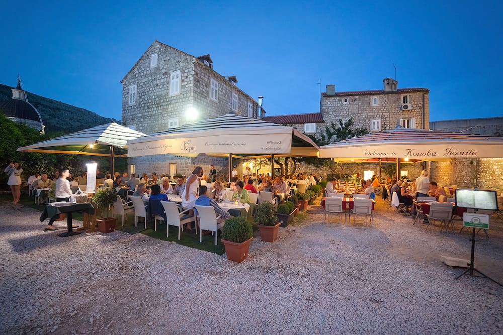 DUBROVNIK, CROATIA - People sitting on terrace of Restaurant Kopun and Konoba Jezuite. Dubrovnik has many restaurants which offer traditional Dalmatian cuisine and some great wine lists.
