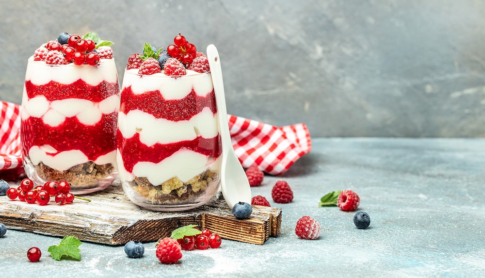 Cranachan raspberry dessert in jar on a light background. Long banner format.