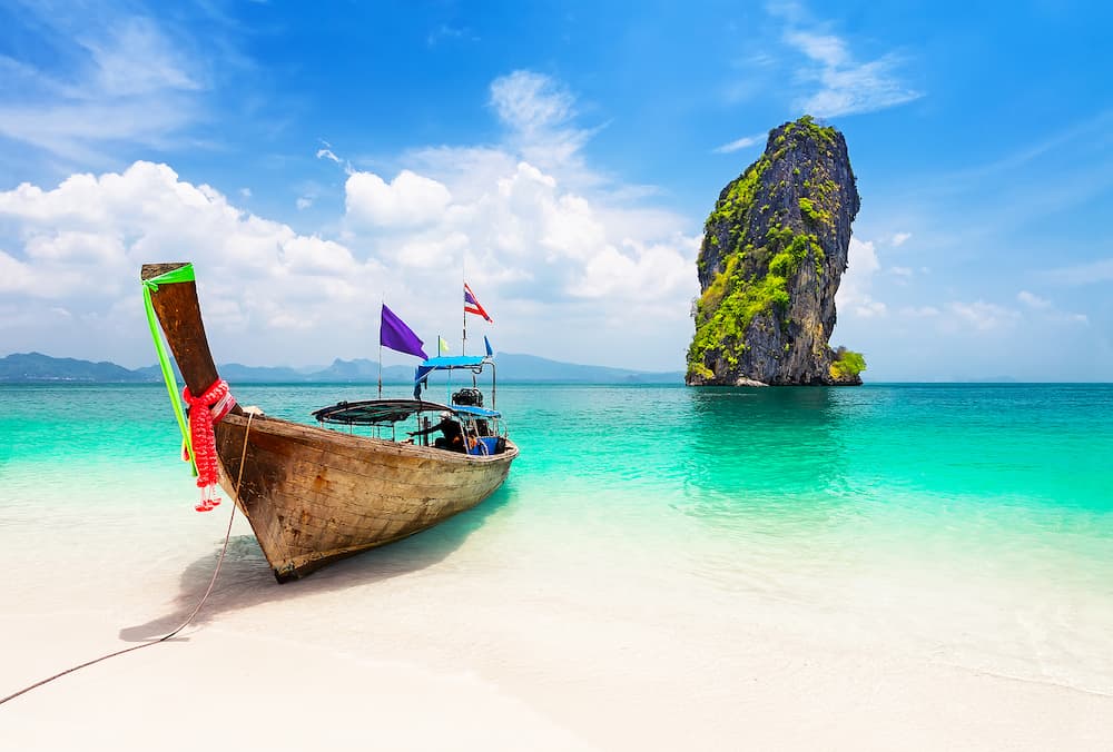 Thai traditional wooden longtail boat and beautiful sand beach at Koh Poda island in Krabi province. Ao Nang, Thailand.