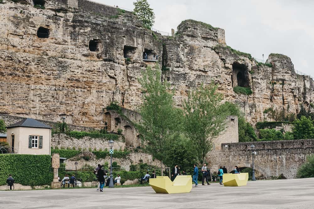 Luxembourg City,Luxembourg - People walking in Old Town of Luxembourg, Bock Casemates, a vast complex of underground tunnels & galleries used as WWII bomb shelters, on the background.