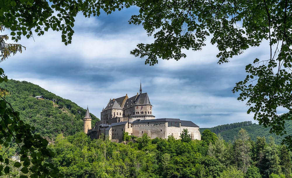 Vianden, Luxembourg - the historic Vianden Castle in Luxembourg framed by lush green summer forest