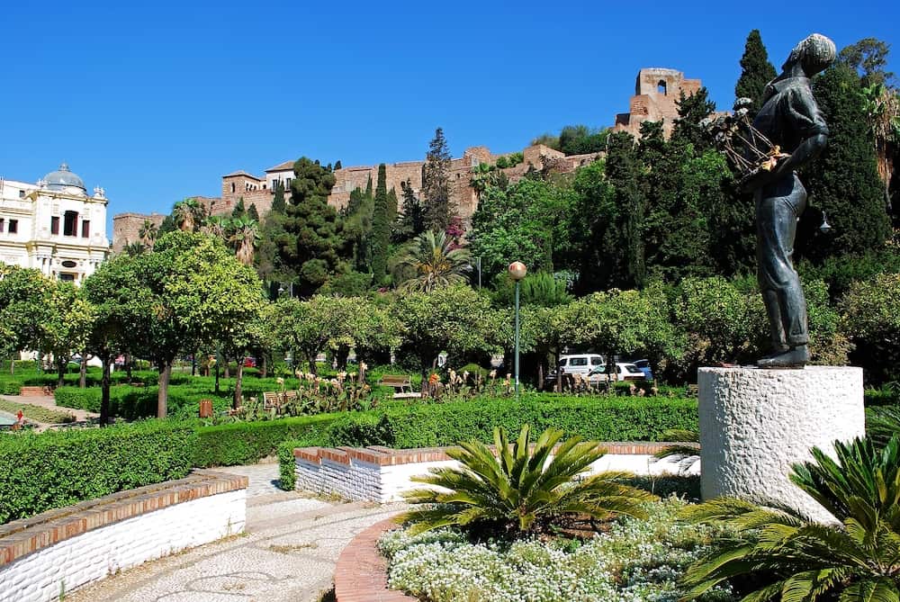 MALAGA, SPAIN - Flower seller statue of Biznaguero in the Pedro Luis Alonso gardens with the castle to the rear, Malaga, Malaga Province, Andalucia, Spain, Western Europe, 