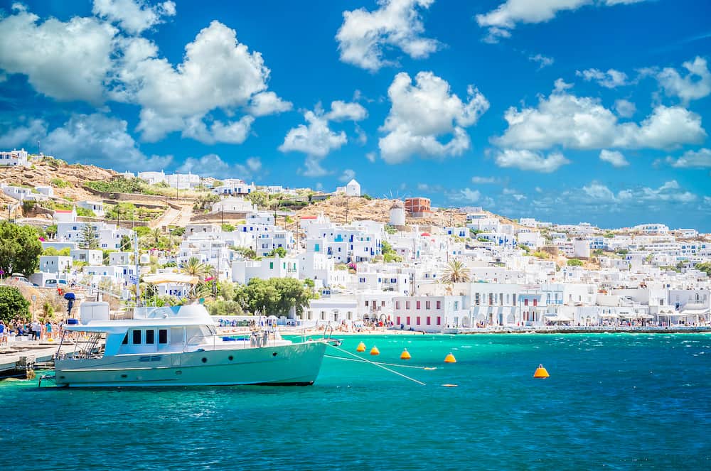 Beautiful view of Mykonos town in Cyclades Islands. There are white houses and boats in the old harbor.