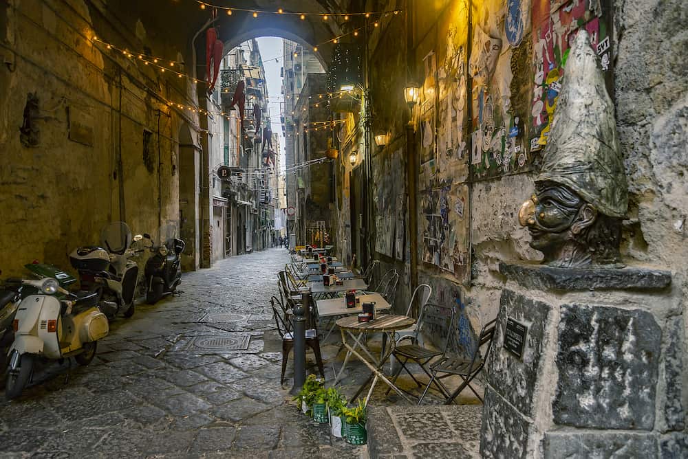 NAPLES, ITALY - narrow streets of the histrorical center, the traditional mask with face of Pulcinella in the old town of Naples, Campania, Italy
