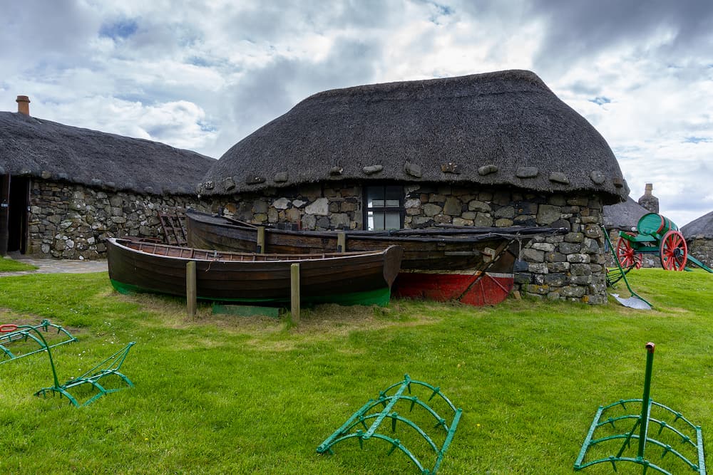 Kilmuir, United Kingdom the Skye Museum of Island Life in Kilmuir on the coast of the Isle of Skye with thatched crofter cottages and boats