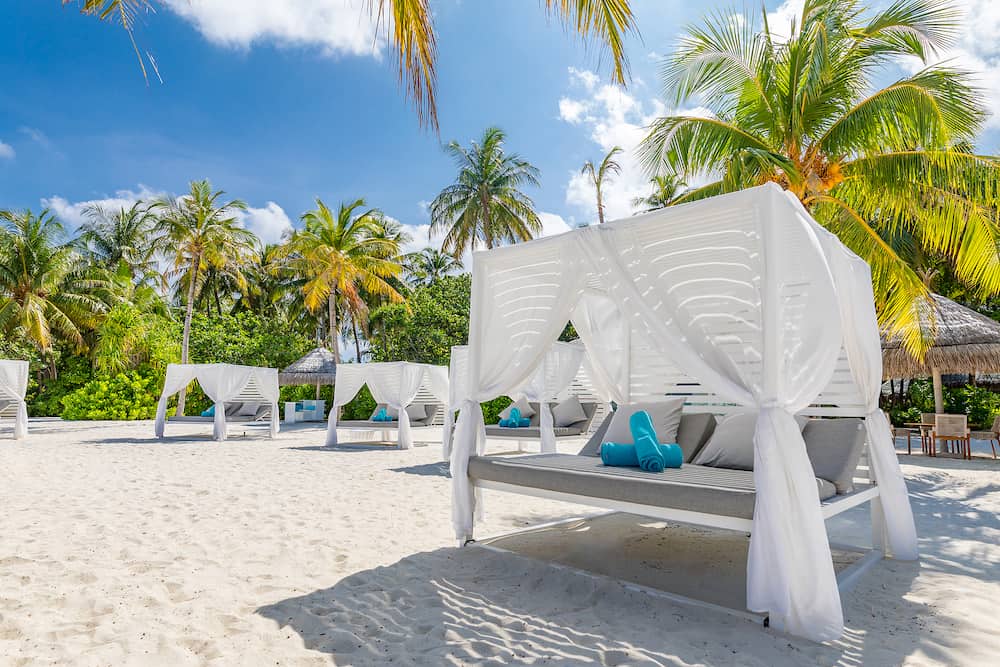 Canopy on exotic beach scene. White beach canopies. Luxury beach tents at a tropical resort. Serenity beach background, luxury beach canopy and travel or summer vacation concept. Luxury beach scene. Summer vacation and holiday concept