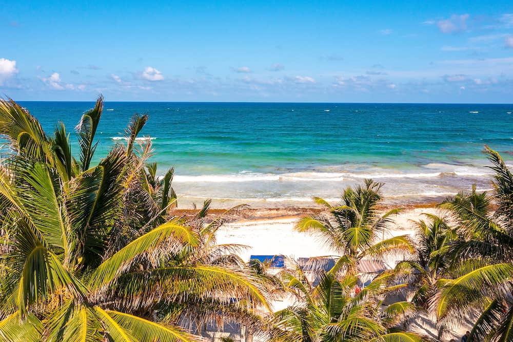 Aerial Tulum coastline by the beach with a magical Caribbean sea and small huts by the coast.