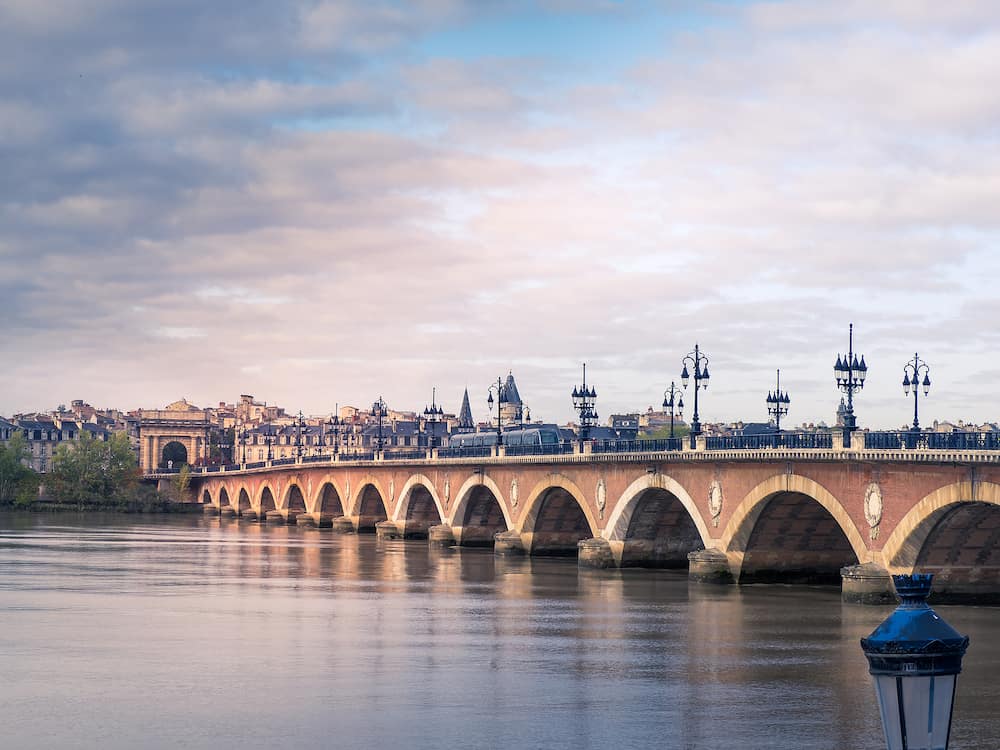Stone bridge over the Garonne River in Bordeaux with the Gourgogne gate. France.