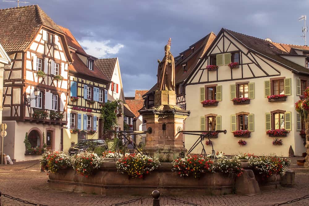 Beautiful view of square of Saint-Leon in the historic town Eguisheim, a popular tourist destination along the famous Alsace Wine Route, in beautiful evening light at sunset in summer, Alsace-Champagne-Ardenne-Lorraine, France