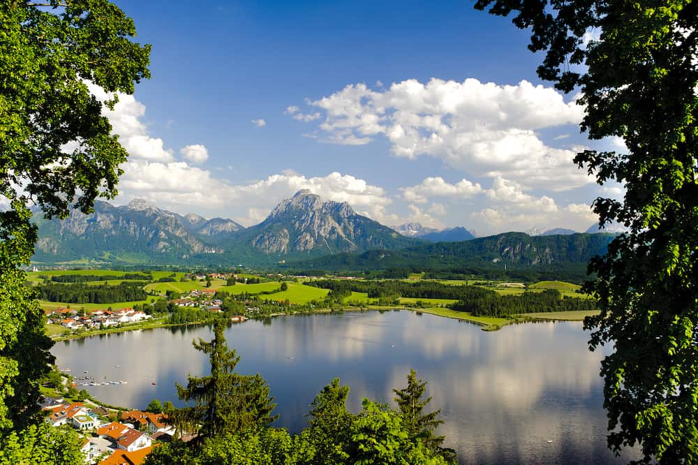 panorama landscape in Bavaria with alps mountains and lake Hopfensee nearby city Fuessen