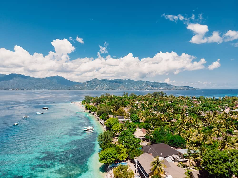 Tropical island with village, beach and turquoise crystal ocean, aerial view. Gili Air island