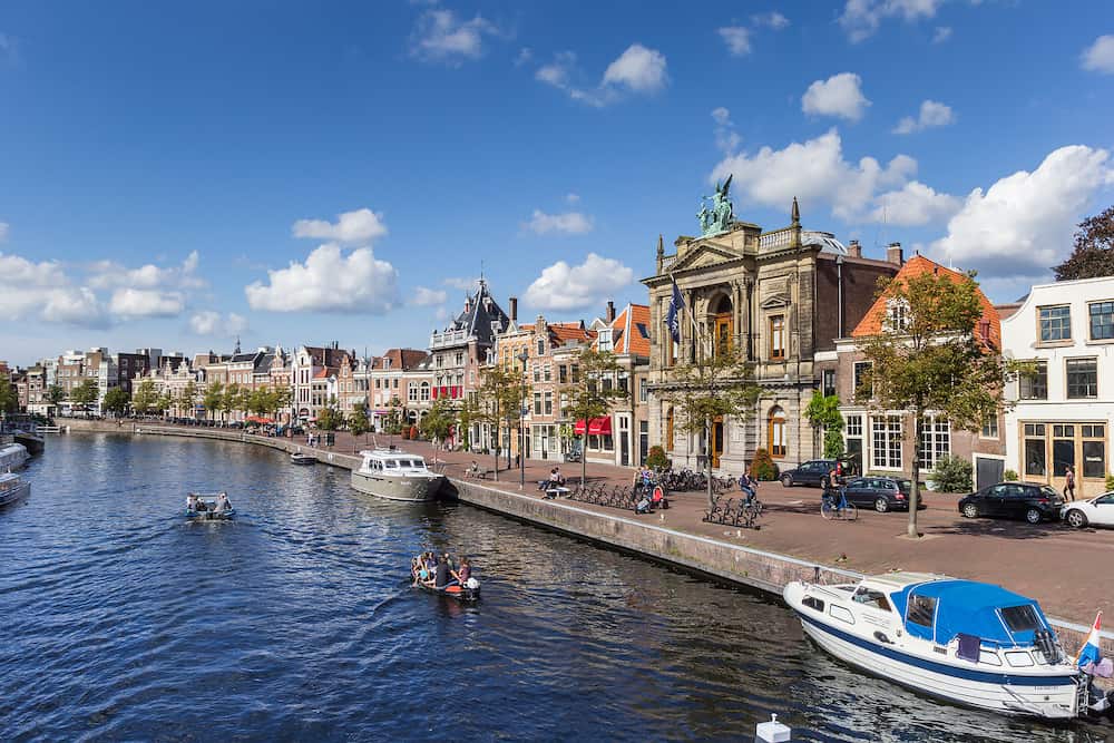 HAARLEM, NETHERLANDS - Canal with boats and old houses at the Spaarne in Haarlem Netherlands