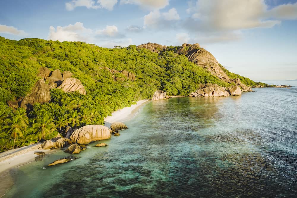 Golden sunset vibe colors at Anse Source D Argent exotic beach at Seychelles. Aerial drone above photo