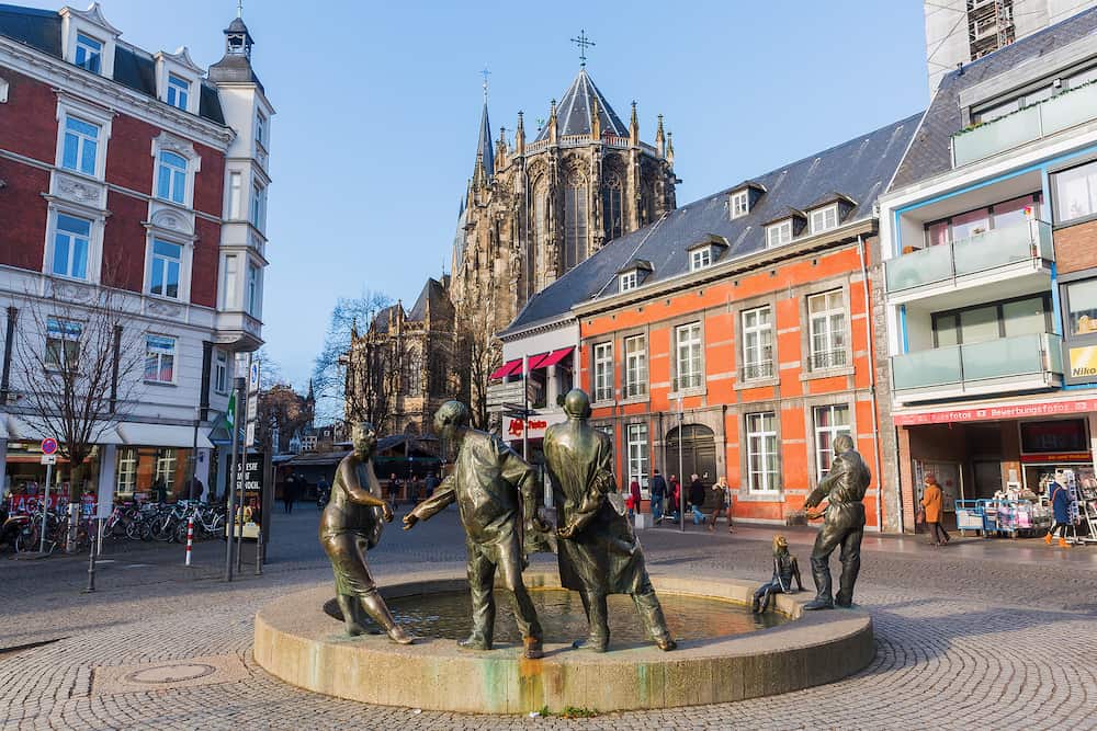 Aachen Germany - bronze statue named circulation of money in Aachen with unidentified people. Aachen is a spa town in NRW and was residence of Charlemagne