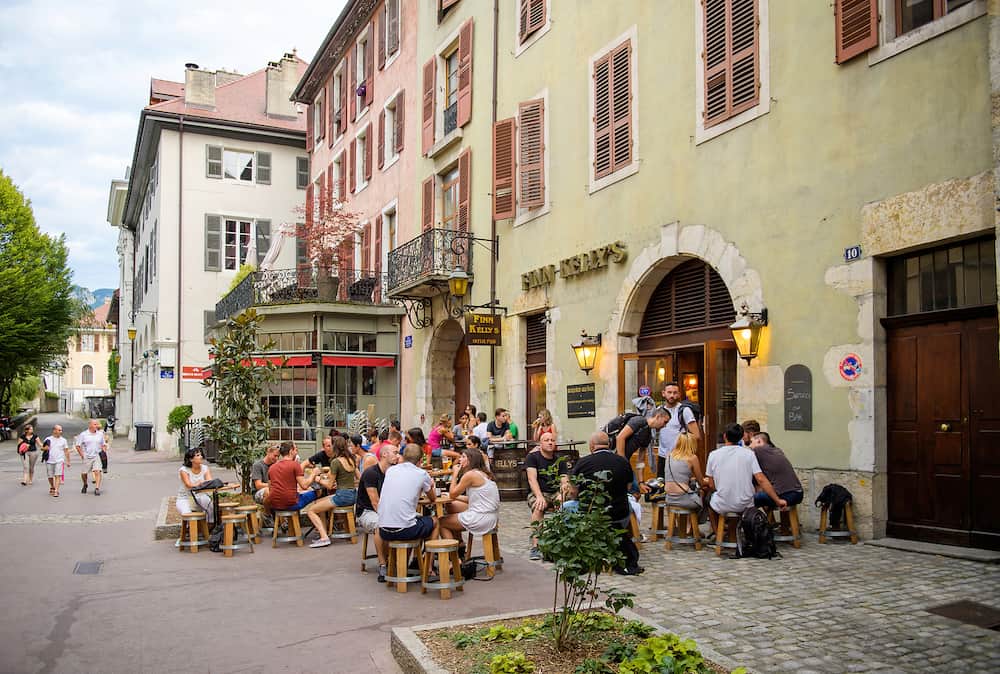 Annecy, France - Large group of people eating drinking smoking at the outdoor terrace of Finn Kellys pub beer restaurant cafe