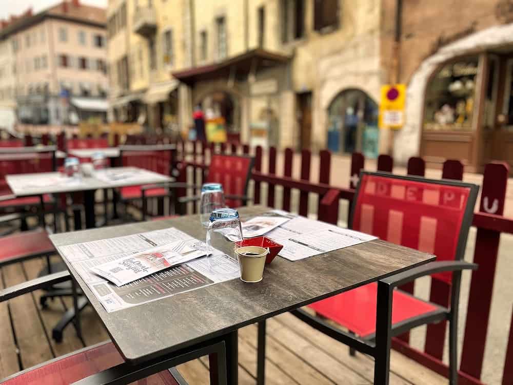 Annecy, France - in a small provincial village tables on the terrace of a restaurant have been prepared for lunch