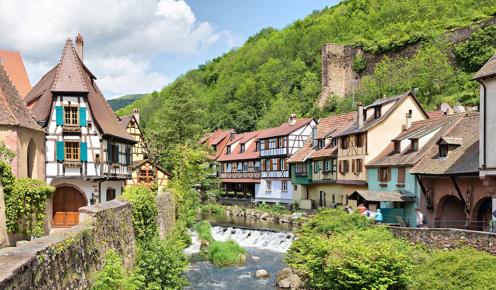 French traditional half-timbered houses and La Weiss river in Kayserberg village in Alsace France