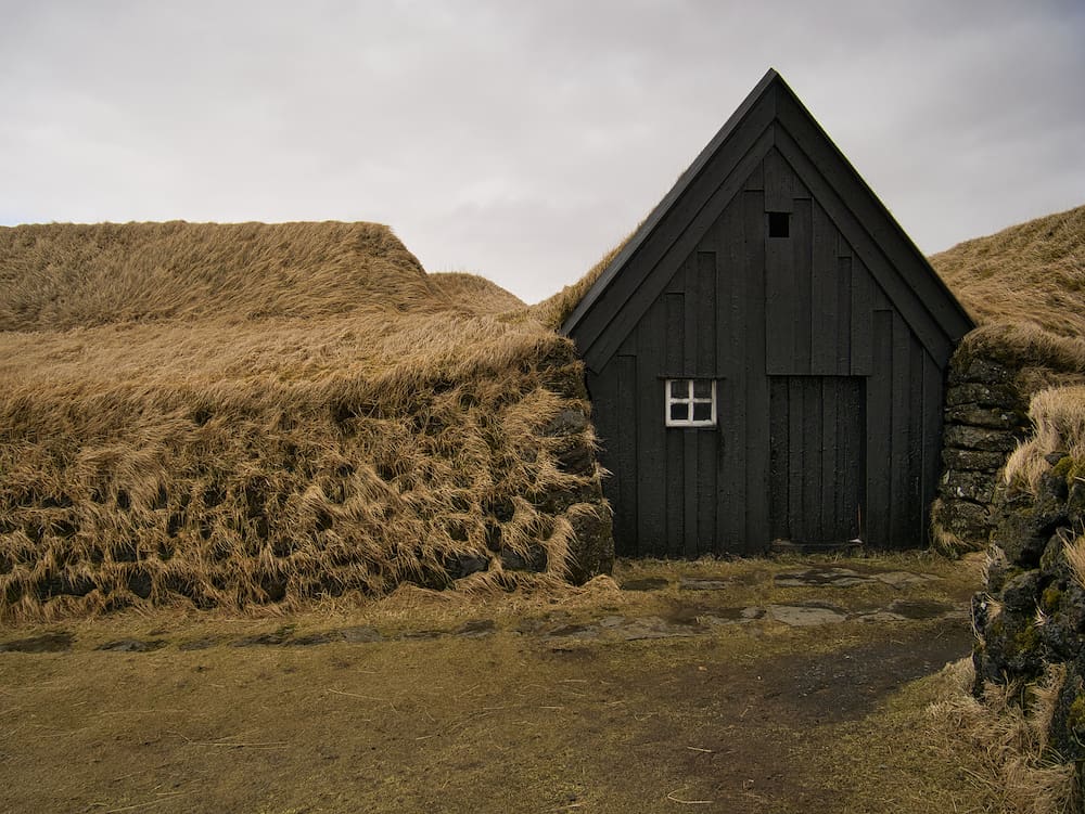 The facade of a wooden house surrounded by peat in Keldur near Hella