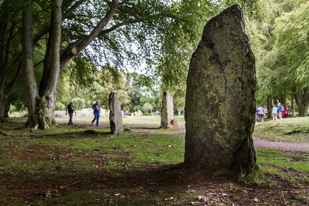 Scotland - Tourists Exploring Clava Cairns, a bronze age burial site near Inverness, UK 