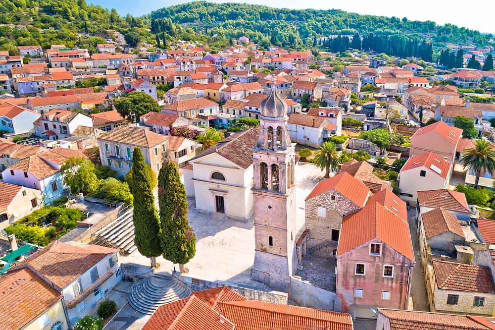 Korcula island. Town of Vela Luka church tower and rooftops aerial view, archipelago of southern Dalmatia, Croatia