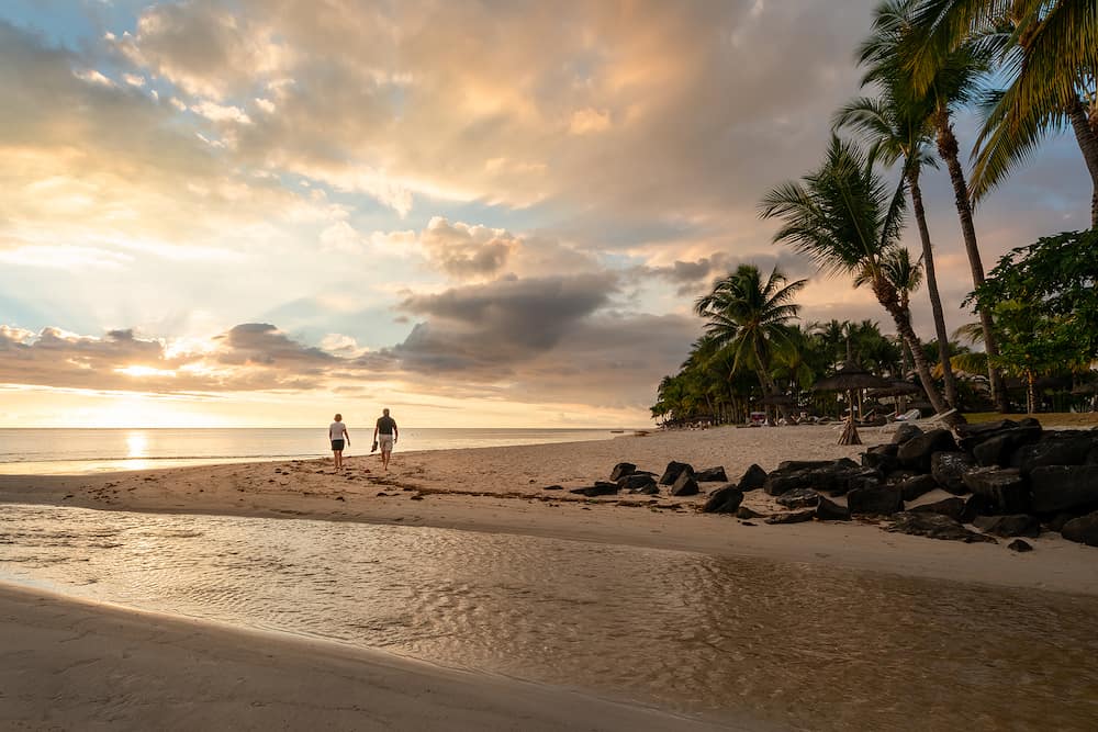 A couple walking on the beach at sunset, Flic en flac beach, mauritius island