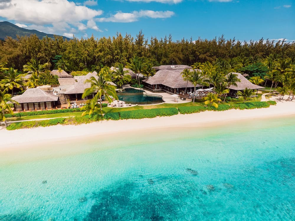Luxury beach with hotel resort in Mauritius. Sandy beach with palms and blue ocean. Aerial view