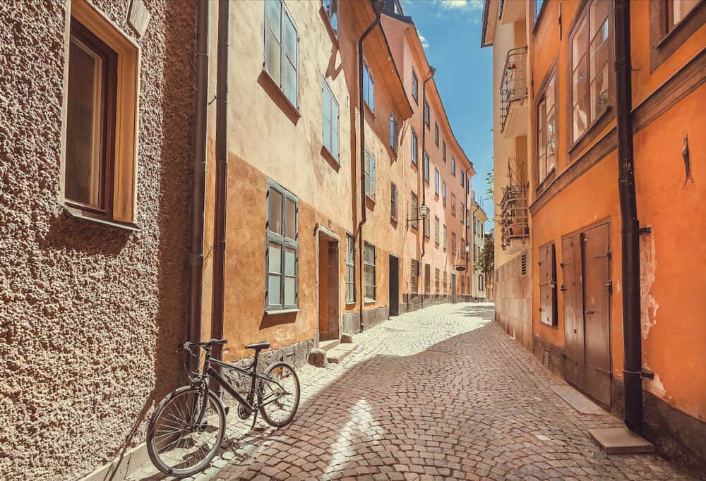 Bicycle abandoned on narrow colorful street with old houses of Gamla Stan, Old Town in Sockholm, Sweden