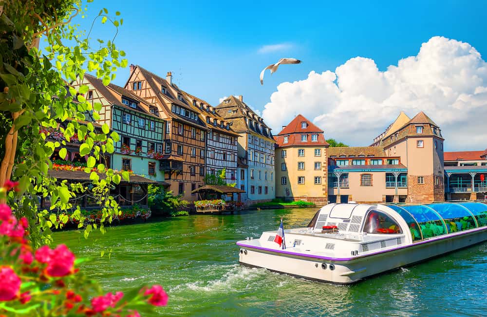 Excursion boat In River By Buildings In Strasbourg