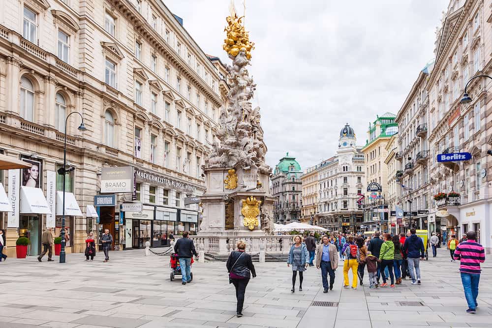 VIENNA AUSTRIA - tourists on Graben street near Plague column (Pestsaule) in Vienna. The Graben is one of the most famous streets in Vienna first district the city centre.