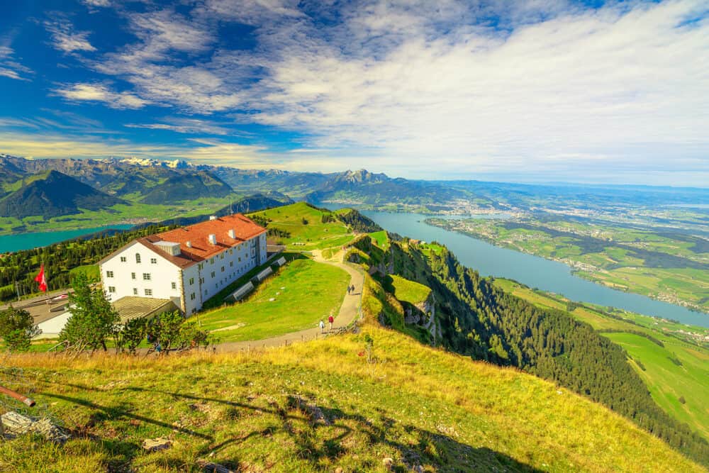 Panoramic views along trail around Rigi Kulm, the highest peak on Mount Rigi over 13 lakes and peaks of Swiss Alps. Canton of Lucerne, Central Switzerland. Green meadows, outdoor activities in summer.