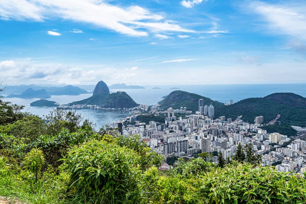 View from Mirante Dona Marta of Guanabara Bay and Sugarloaf mountain with blue sky and mountains in the background and Atlantic Ocean in Rio de Janeiro, Brazil, South America
