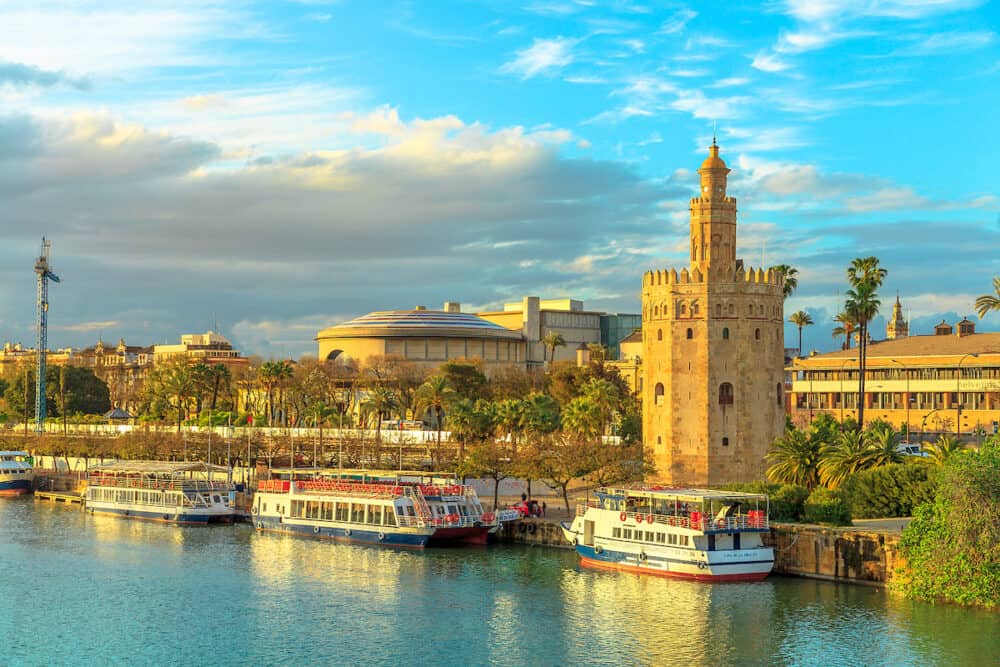 Seville, Andalusia, Spain -  Golden tower or Torre del Oro, a medieval military control tower on riverside of Seville at sunset. City sightseeing from Guadalquivir River Cruise.