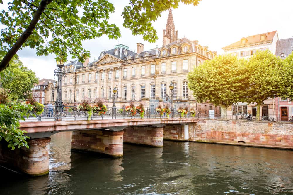 View on the water channel with Rohan palace and bridge in Strasbourg city in France