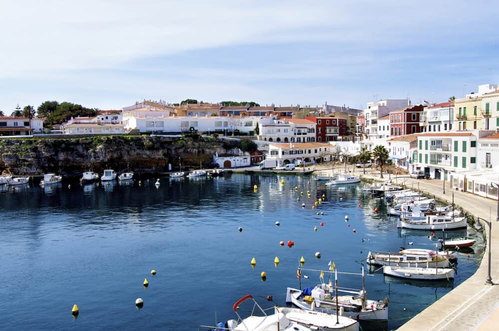 Es Castell Harbor Traditional Houses and Lagoon on Blue Skies background Menorca Balearic Islands