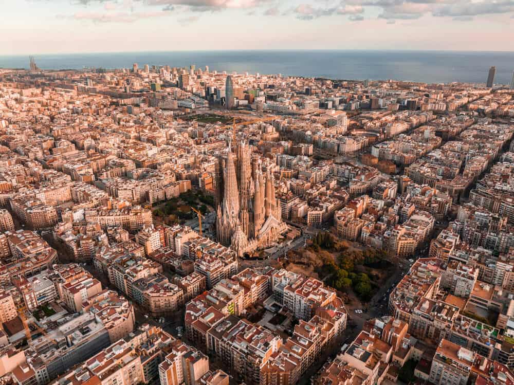 Aerial view of Barcelona City Skyline and Sagrada Familia Cathedral at sunset.