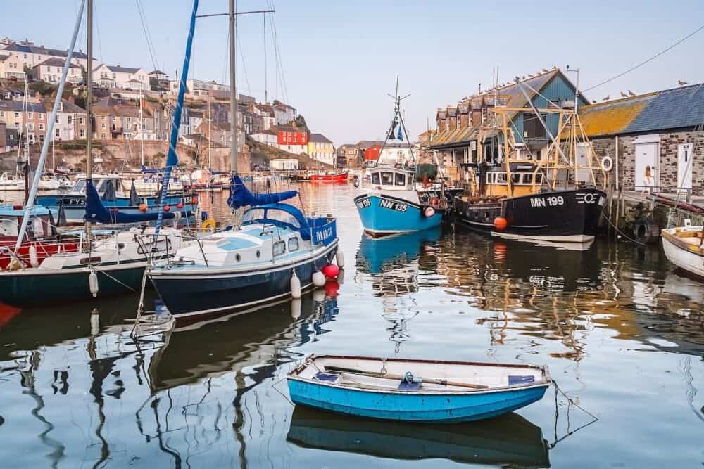 CORNWALL, UK - Fishing boats and sailing yachts moored in Mevagissey harbour, Cornwall, UK