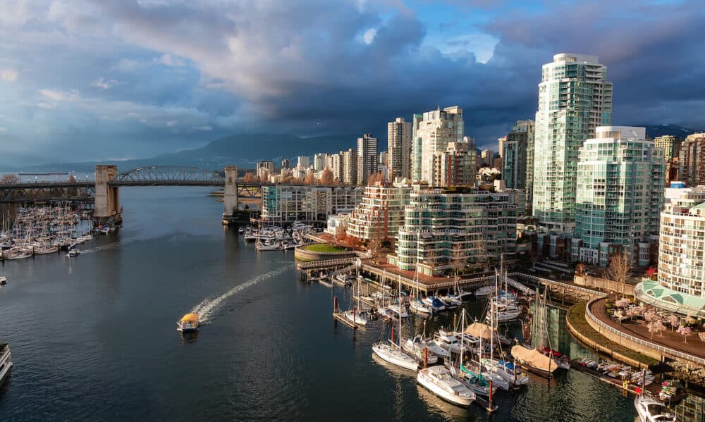 Aerial View of Granville Island in False Creek with modern city skyline and mountains in background. Downtown Vancouver, British Columbia, Canada. Sunset Sky