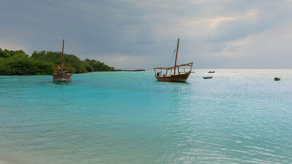 Anchored wooden dhow boats on the amazing turquoise water in the Indian ocean Zanzibar Tanzania.