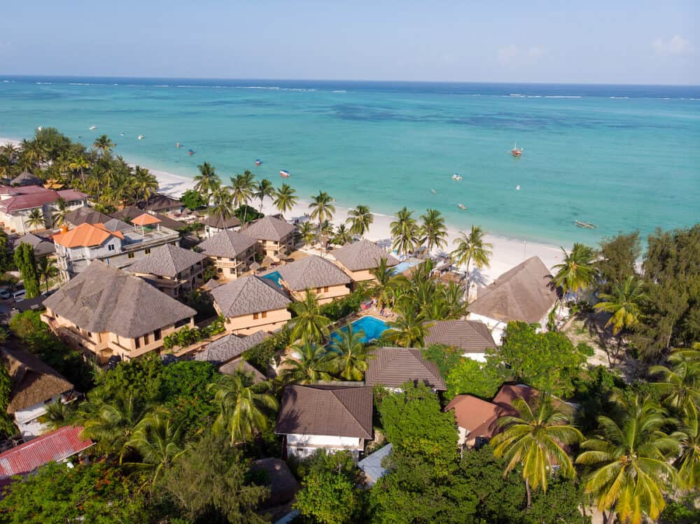 Aerial shot of a luxury hotel on a Beach first line with Palm Trees Garden at evening time in Paje village, Zanzibar, Tanzania