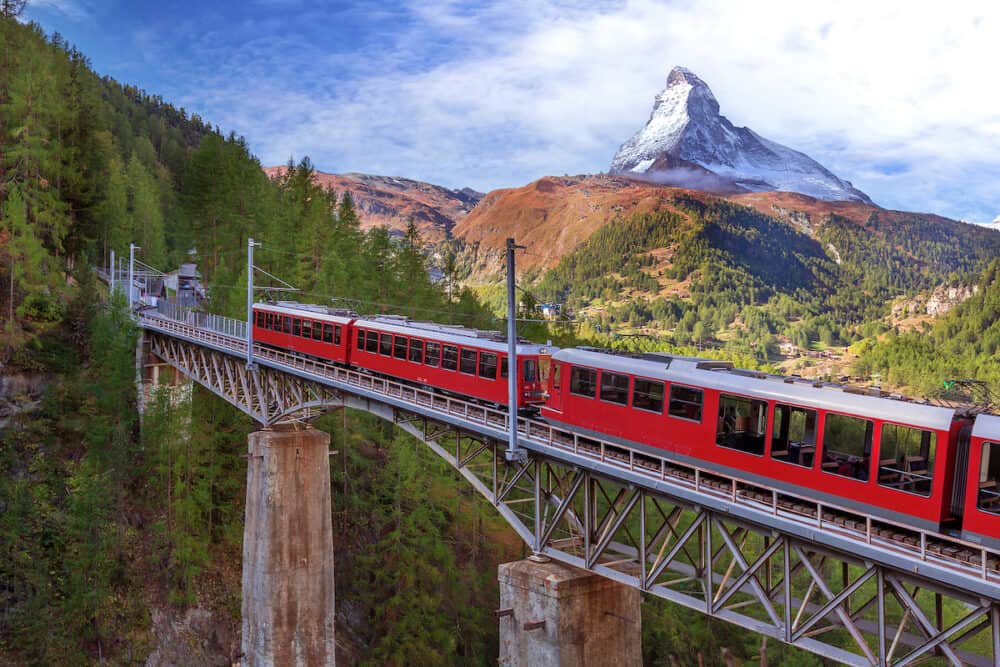 Zermatt, Switzerland. Gornergrat red tourist train on the bridge and Matterhorn peak panorama in Swiss Alps