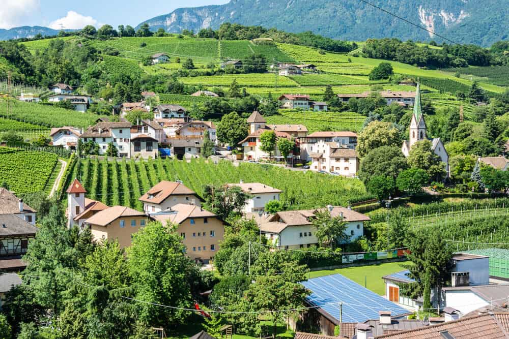 Frangart, South Tyrol, Italy -View over Frangart village in South Tyrol, Italy, with residential and commercial buildings and vegetation, on a sunny summer day.