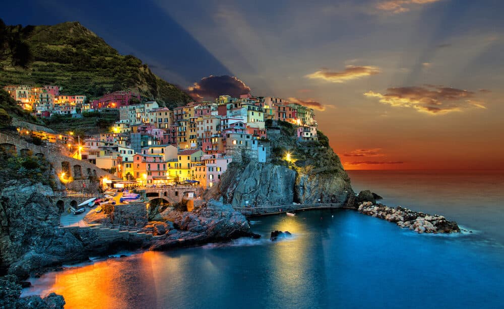 Sunset over Manarola town, one of five famous colorful villages of Cinque Terre National Park in Italy.
