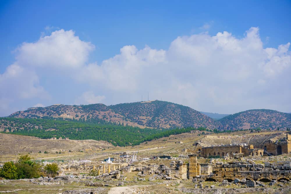 Roman amphitheater in ruins Hierapolis, in Pamukkale, Turkey. UNESCO World Heritage in Turkey. Ruined ancient city in Europe. Popular tourist destination in Turkey against blue sky